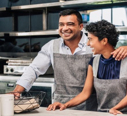man and teen laughing in kitchen